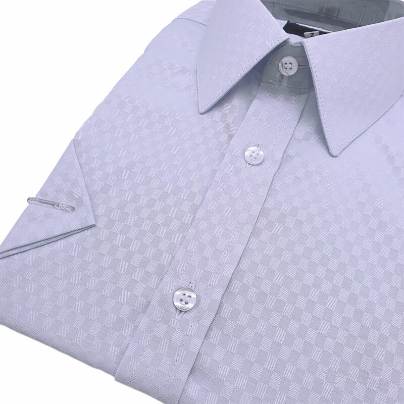 Camisa manga curta azul xadrez dobrada em ângulo, botões claros e peitilho.