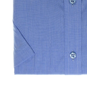 Detalhe da manga curta e peitilho da camisa azul lisa com botões.