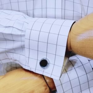 Close do punho duplo da camisa branca xadrez preto italiana com abotoadura escura.