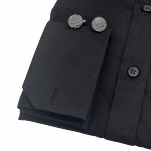 Close do punho da camisa preta lisa sulfite com abotoaduras metálicas de formato geométrico sobre o tecido.