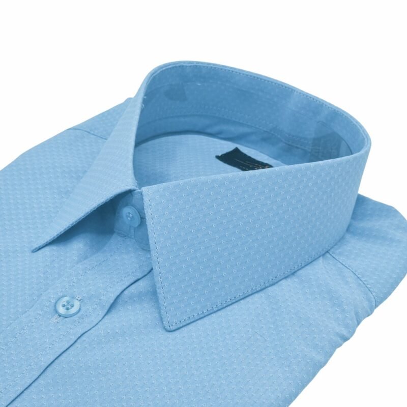 Close da gola estruturada e parte superior do peito da camisa punho duplo azul claro francesa em fundo branco.