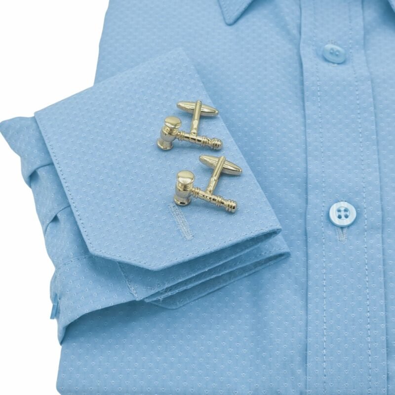 Close do punho duplo azul claro da camisa francesa com abotoaduras metálicas em evidência.