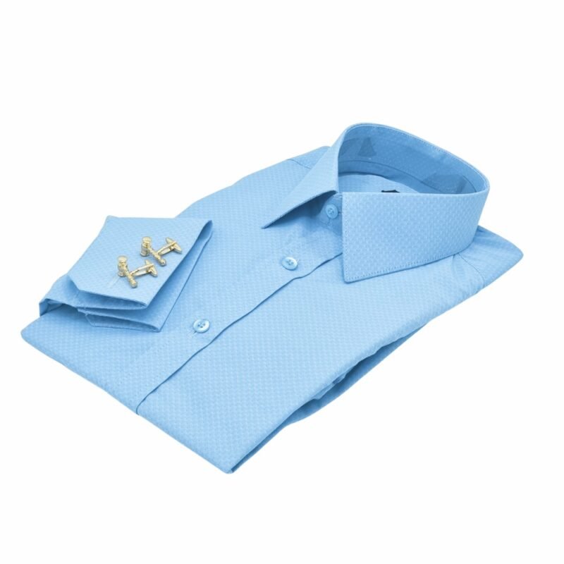 Camisa punho duplo azul claro francesa dobrada em ângulo diagonal mostrando punho e abotoaduras sobrepostas.