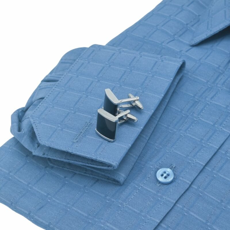 Close do punho duplo azul xadrez largo da camisa com abotoaduras metálicas em destaque.