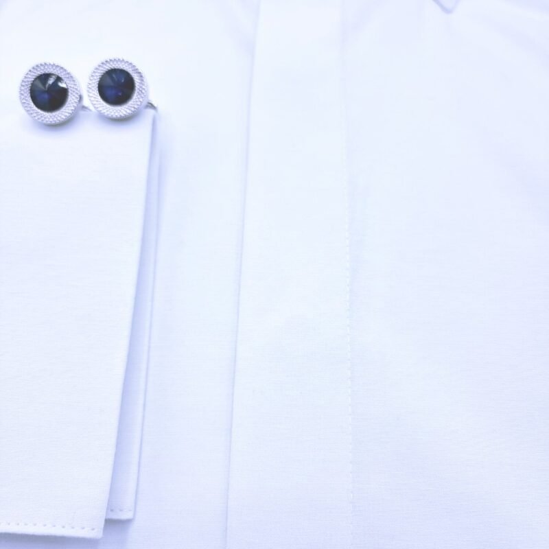 Close do punho duplo da camisa italiana branca lisa com abotoaduras e parte da vista frontal com botões cobertos.