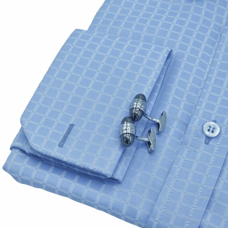Close do punho duplo da camisa azul xadrez da Ms Stilos com abotoaduras metálicas, evidenciando textura do tecido em algodão passa fácil e acabamento refinado.