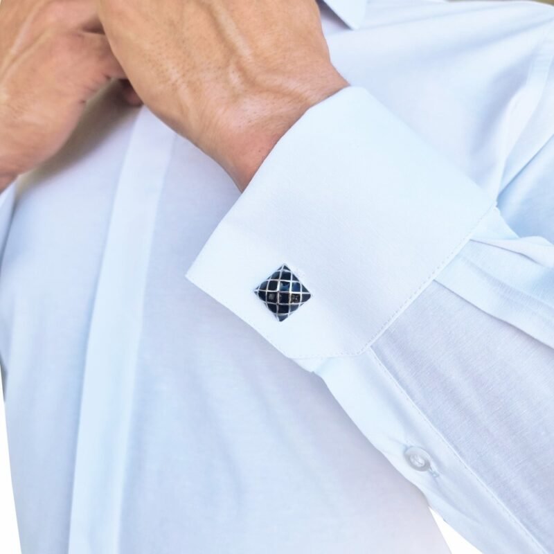 Detalhe do punho duplo da camisa branca lisa francesa, com abotoaduras em destaque e acabamento de alfaiataria.