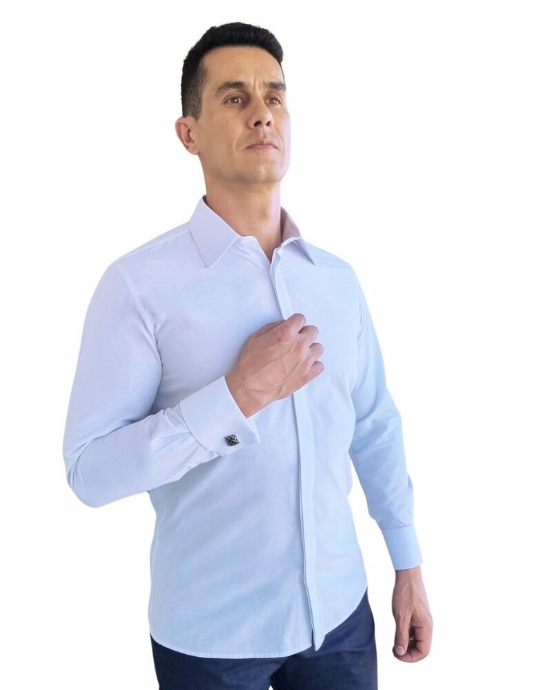 Modelo veste camisa branca lisa francesa com punho duplo, em enquadramento 3/4, destacando caimento semi slim e presença elegante.