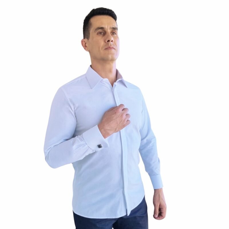 Modelo veste camisa branca lisa francesa com punho duplo, em enquadramento 3/4, destacando caimento semi slim e presença elegante.
