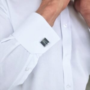 Close do punho duplo da camisa branca lisa italiana semi slim com abotoaduras escuras.