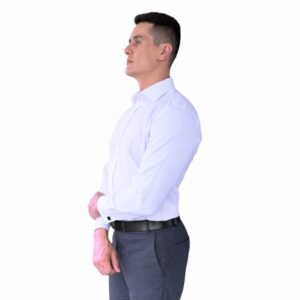 Modelo em vista lateral vestindo camisa branca lisa italiana semi slim com punho duplo para abotoaduras.