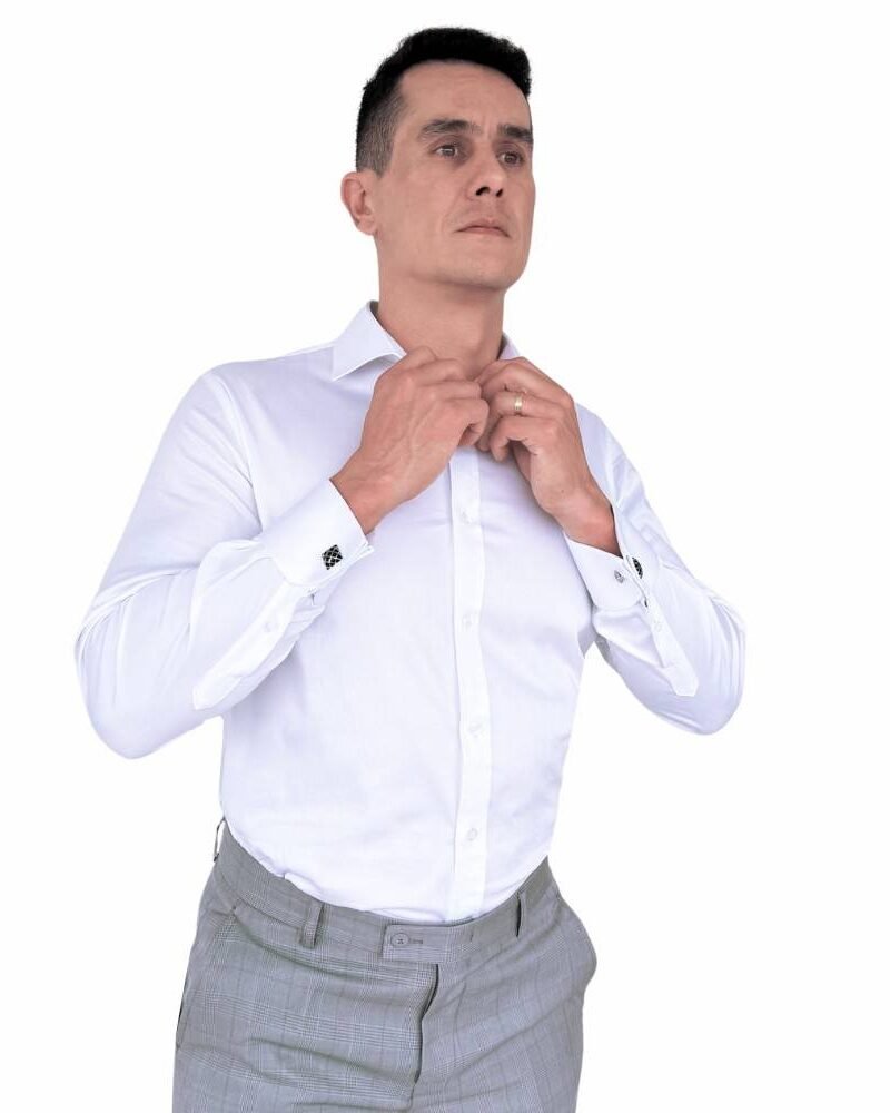 Modelo veste camisa italiana branca em algodão egípcio com elastano e ajusta a gola, evidenciando o caimento semi slim e elegante.