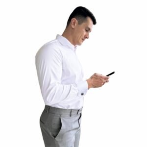Modelo veste camisa italiana branca em algodão egípcio com elastano em vista lateral, evidenciando caimento semi slim e discrição elegante para o dia a dia executivo.