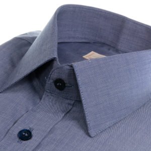 Close do tecido da camisa azul 100% algodão francesa e da gola, mostrando textura fina, elegância e qualidade premium.