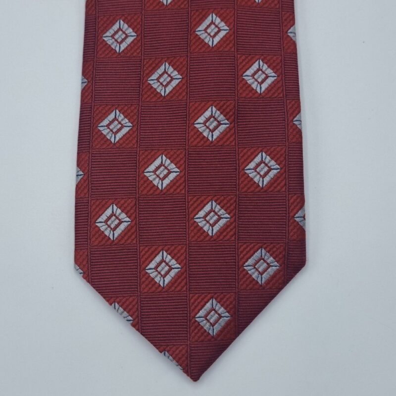 Detalhe da ponta da gravata extra long vermelha em seda com padrão geométrico