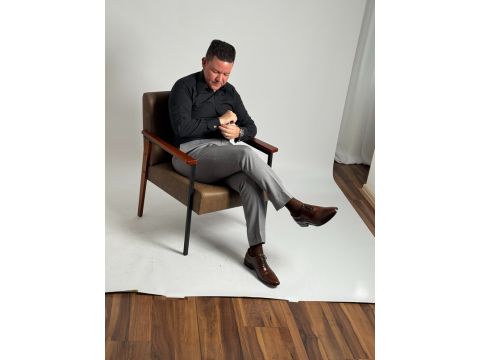 Samuel ajustando a manga da camisa com expressão concentrada, representando cuidado com detalhes e preparação para uma consultoria de estilo personalizada.