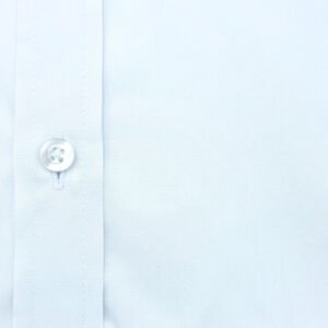 Close da textura do tecido da camisa branca lisa em algodão egípcio com elastano, mostrando o botão frontal e a trama discreta.