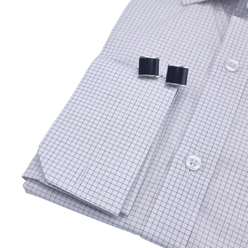 Punho da camisa quadriculada branca e bordô com abotoadura, estilo social clássico.