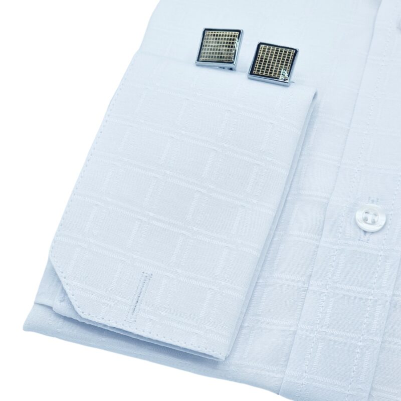 Punho da camisa social branca quadriculada com abotoadura metálica, close.