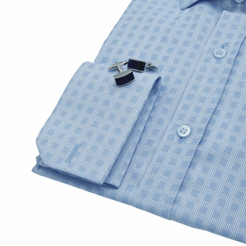 Detalhe do punho duplo da camisa social azul italiana xadrez dobrada, com par de abotoaduras metálicas em destaque sobre o punho