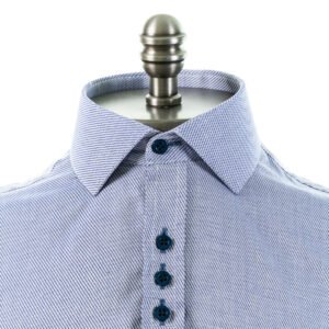 Close frontal da camisa azul com gola italiana em algodão 100%, destacando colarinho estruturado, textura do tecido e fileira de botões.