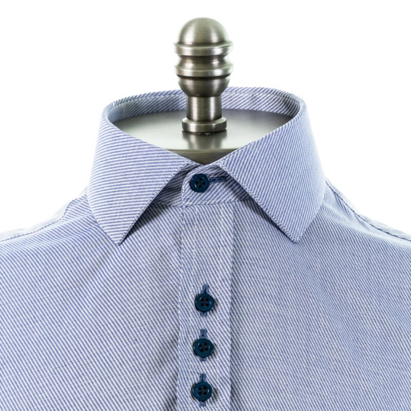Close frontal da camisa azul com gola italiana em algodão 100%, destacando colarinho estruturado, textura do tecido e fileira de botões.