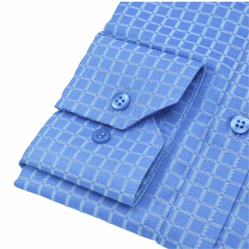 Close do punho com botão da camisa azul xadrez italiana passa fácil, destacando a textura do tecido.
