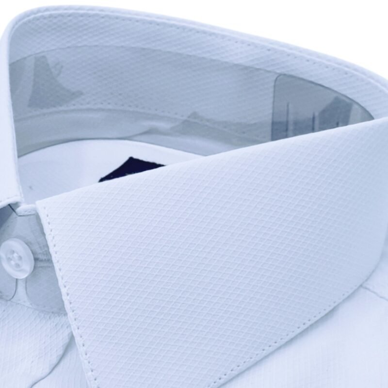 Close da textura maquinetada escama de peixe na gola da camisa branca da MS Stilos.