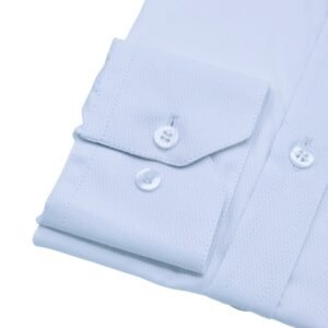 Detalhe do punho com botões da camisa branca maquinetada escama peixe sobre fundo branco.