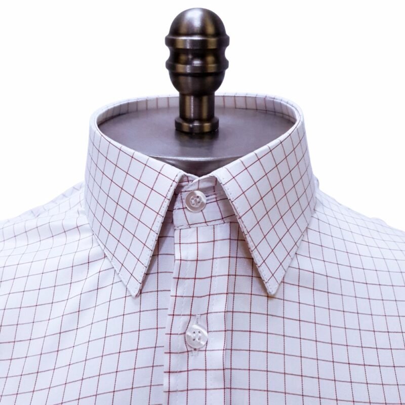 Detalhe frontal da camisa fio egípcio branca xadrez vermelho, destacando colarinho estruturado e abotoamento central em algodão nobre.
