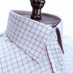 Vista diagonal do colarinho da camisa fio egípcio branca xadrez vermelho, mostrando a estrutura da gola e a padronagem do tecido em detalhe.