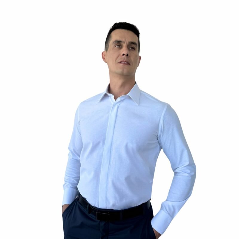 Camisa francesa branca lisa sulfite, com foco nas costuras, transmitindo cuidado de construção e acabamento premium.