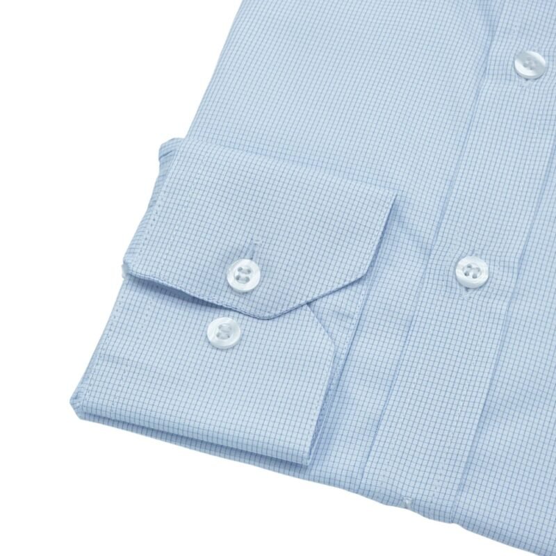 Close do punho com botões da camisa francesa branca quadriculada azul claro sobre fundo branco.