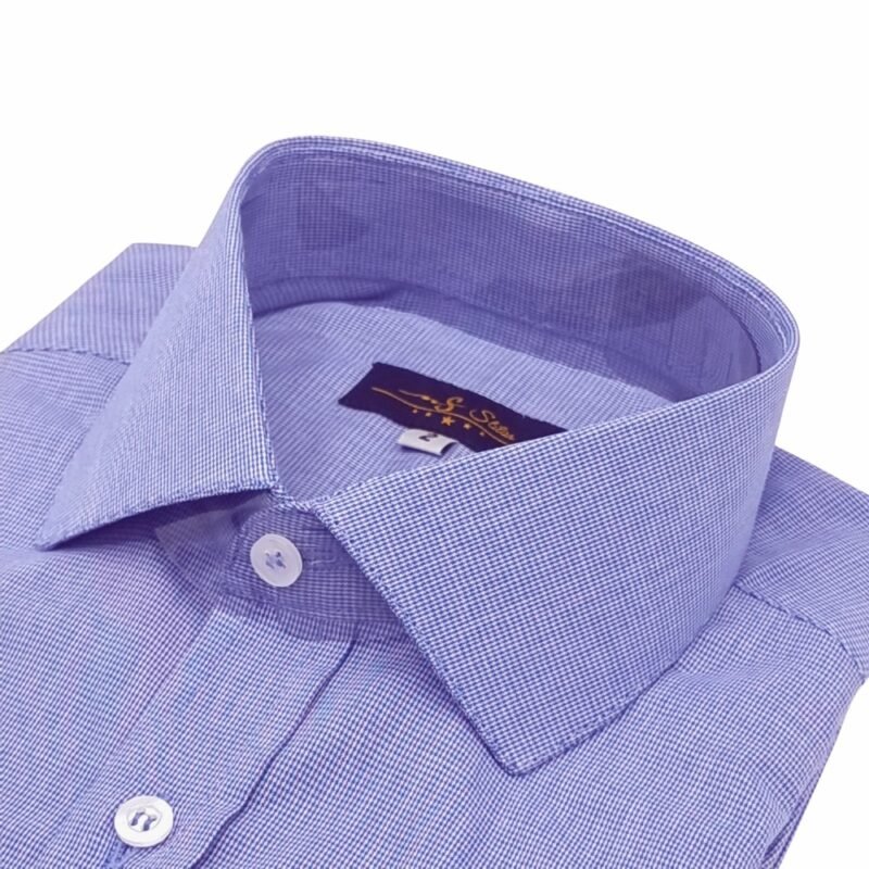 Close em ângulo da gola italiana rígida e do colarinho da camisa azul royal com micro estampa, destacando o alinhamento dos botões e a textura discreta do tecido