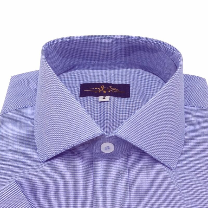 Close superior da gola italiana da camisa azul royal com micro estampa, mostrando o colarinho aberto, a etiqueta interna da marca e a textura quadriculada do tecido