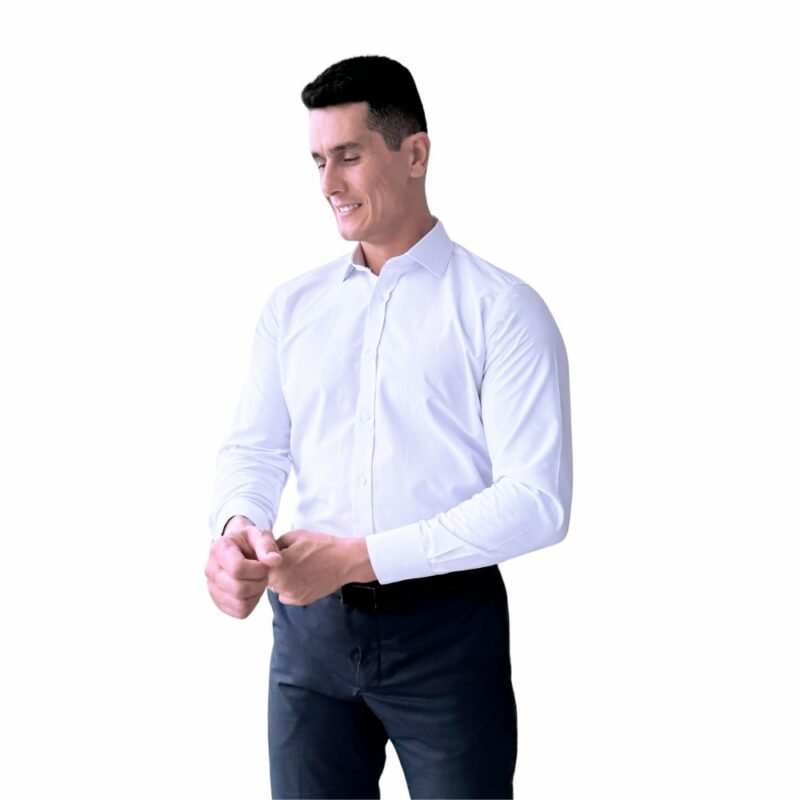 Modelo veste camisa italiana branca lisa sulfite semi slim de frente, ajustando o punho em fundo claro.