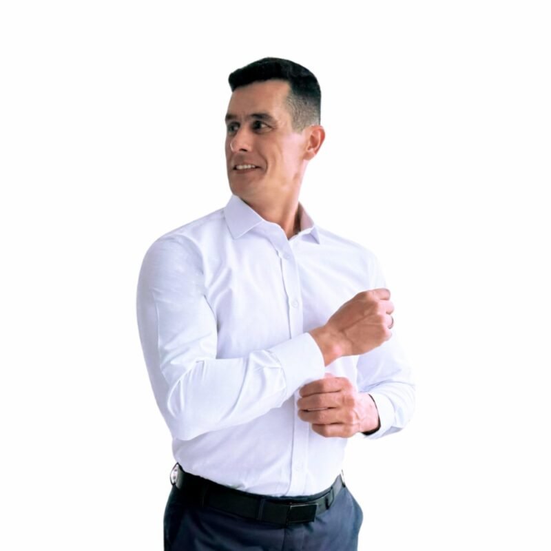 Modelo ajustando o punho da camisa italiana branca lisa sulfite semi slim, sorrindo em ambiente claro.