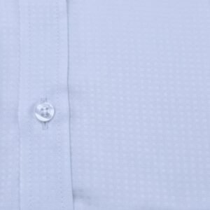 Close do tecido nobre em algodão egípcio com estampa discreta da camisa italiana, mostrando textura, botão e costuras.