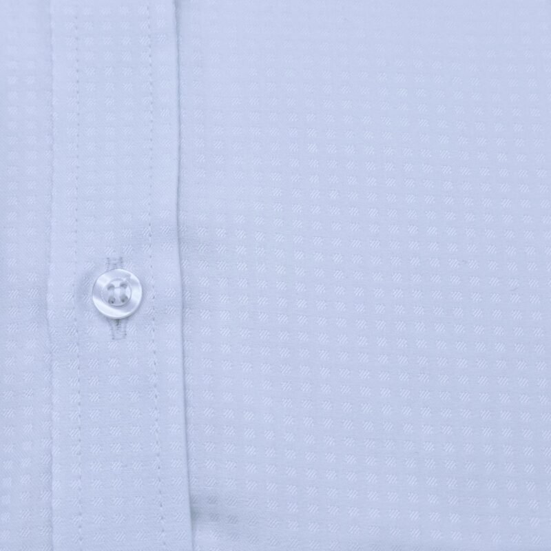 Close do tecido nobre em algodão egípcio com estampa discreta da camisa italiana, mostrando textura, botão e costuras.