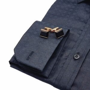 Close do punho duplo da camisa preta italiana xadrez com par de abotoaduras metálicas em destaque sobre o punho dobrado