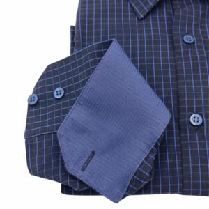 Punho da camisa preta xadrez azul virado para cima, revelando a parte interna em tecido azul texturizado com botões alinhados.