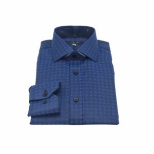 Camisa social azul escuro com gola rígida dobrada sobre superfície clara, com o punho aparecendo ao lado.