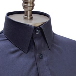 Close da gola francesa estruturada da camisa social azul marinho lisa, com peitilho e botões frontais em destaque.