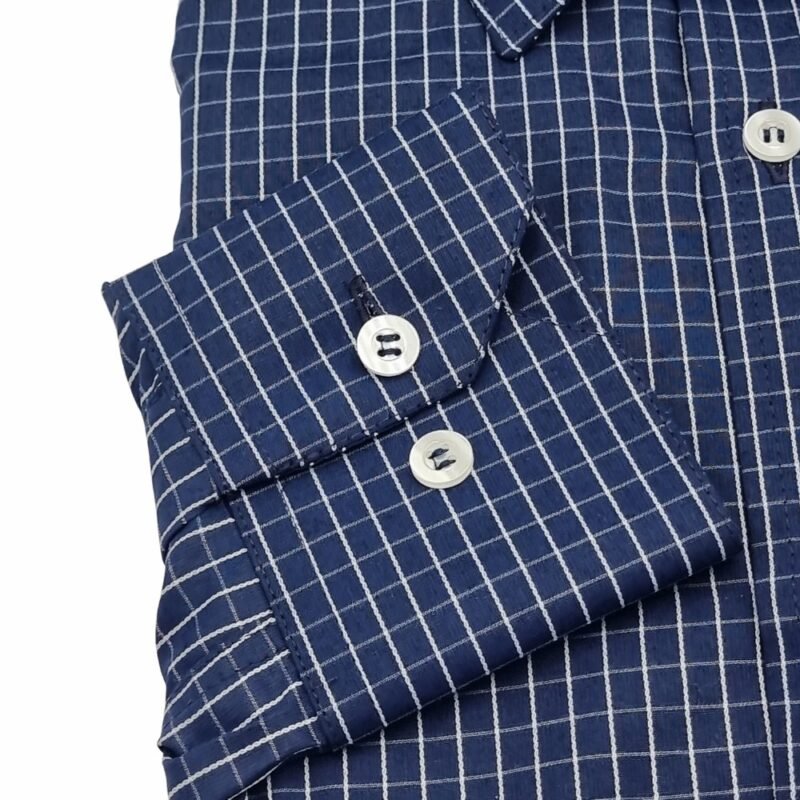 Close do punho com botões da camisa social azul xadrez branco evidenciando o acabamento e o padrão xadrez.