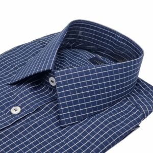 Camisa social azul xadrez branco dobrada com foco na gola francesa e parte do peitoral.
