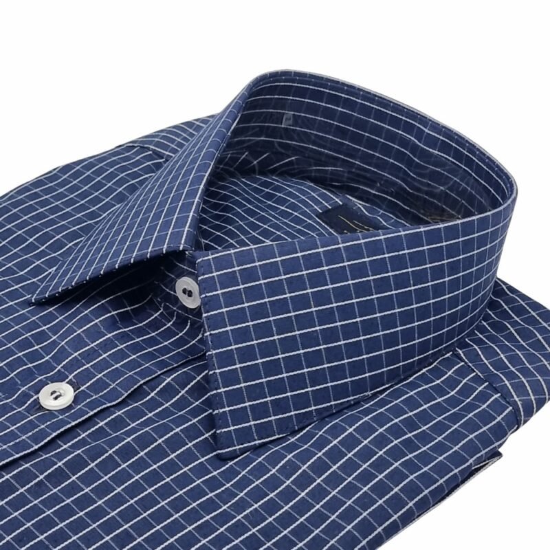 Camisa social azul xadrez branco dobrada com foco na gola francesa e parte do peitoral.