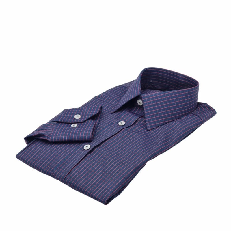 Camisa social azul xadrez vermelho dobrada vista em ângulo diagonal sobre fundo branco.