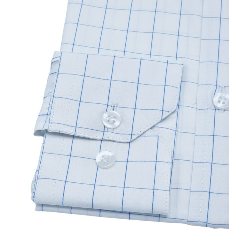 Close do punho de camisa social francesa branca com quadriculado azul claro, com botões brancos em destaque.
