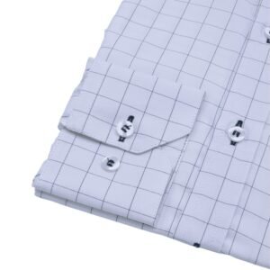 Detalhe do punho com botões e parte da manga da camisa social branca quadriculado azul escuro em tecido passa fácil.