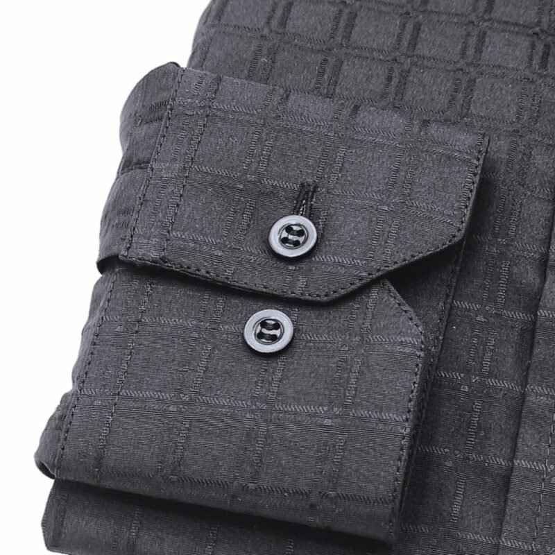 Close do punho com botões da camisa social preta com padronagem xadrez larga, destacando a textura do tecido.